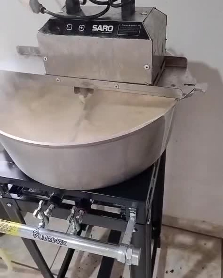 Leite fervendo no tacho, ainda claro, no início do preparo